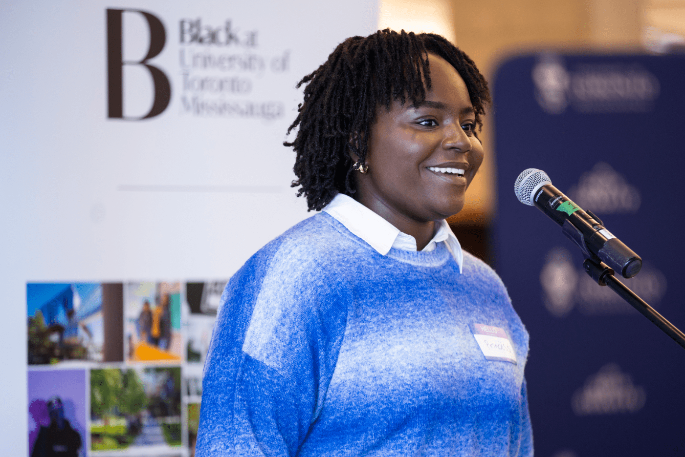 A women smiling on top a podium